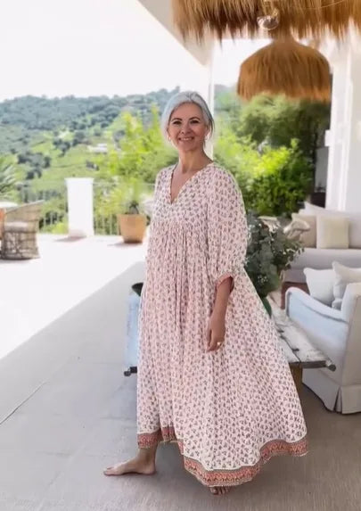 Woman wearing a boho floral print maxi dress with wide sleeves