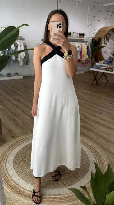 Woman wearing a white halter maxi dress with black trim