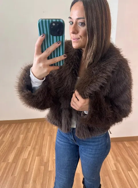 Woman wearing a brown faux fur jacket with jeans