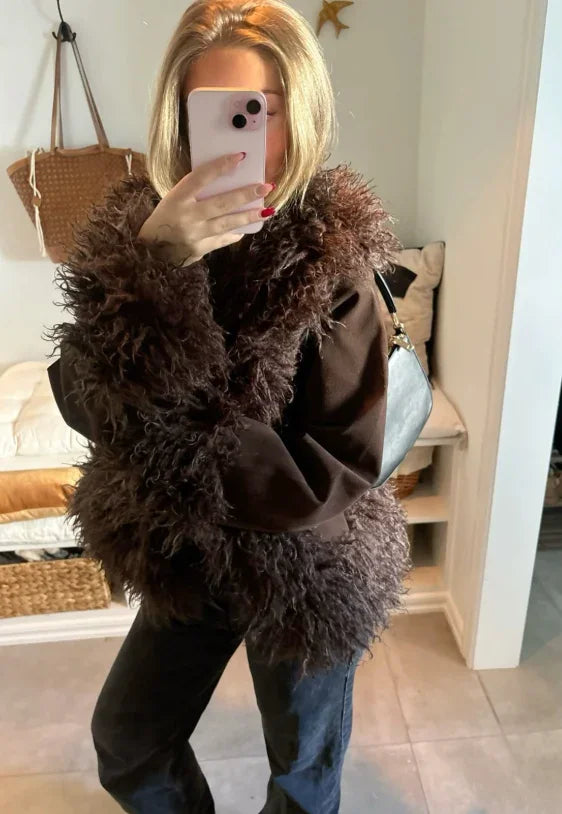 Woman in a black feather jacket and jeans, mirror selfie