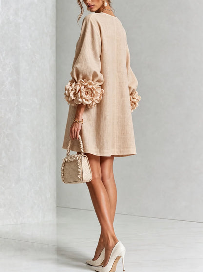 Women's beige button-front mini dress with floral rose cuffs, back three-quarter view