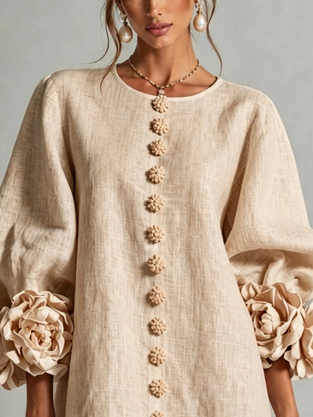 Women's beige button-front mini dress with floral rose cuffs, close-up of the buttons and cuff