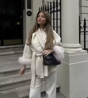 Women's belted wrap coat with fur-style cuffs, white, styled with a bag
