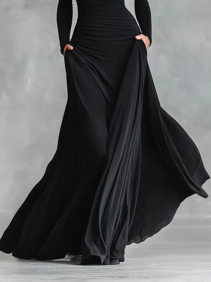 Women's black boat-neck maxi dress with flowing skirt, full-length view of the flowing skirt