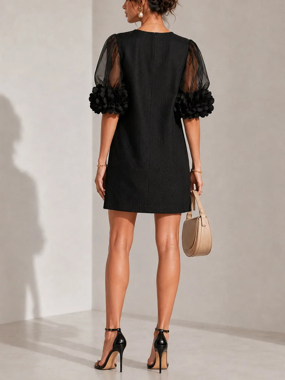 Women's black puff-sleeve mini dress with floral rose cuffs, back three-quarter view
