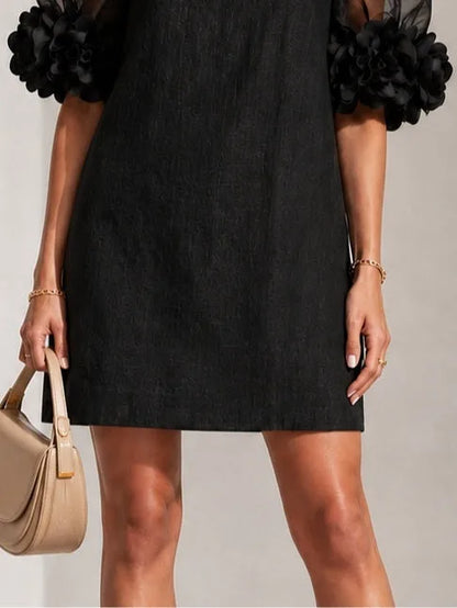 Women's black puff-sleeve mini dress with floral rose cuffs, close-up of the cuff and pocket