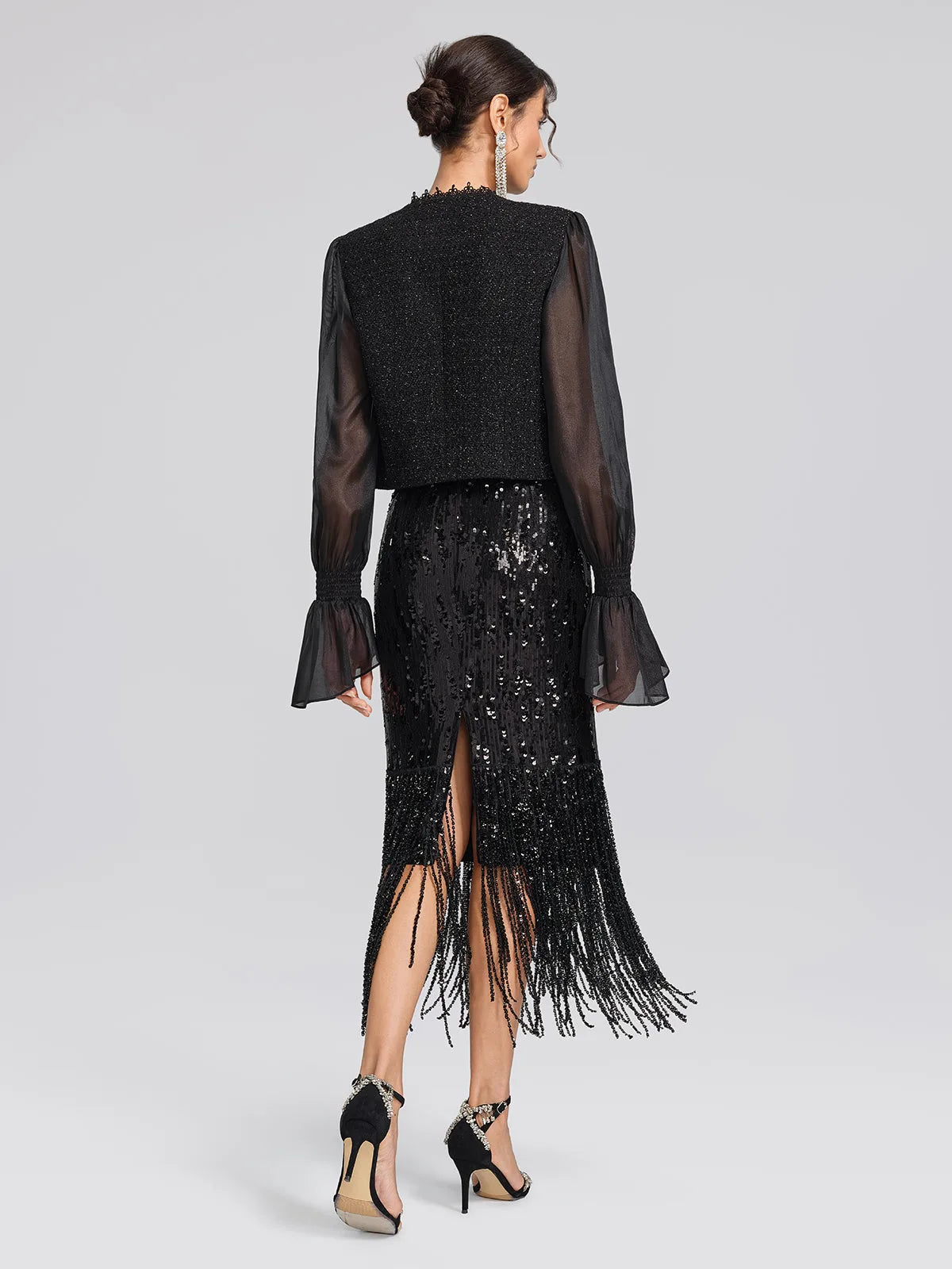 Women's black sequin fringe midi skirt with slit, back view with a black jacket
