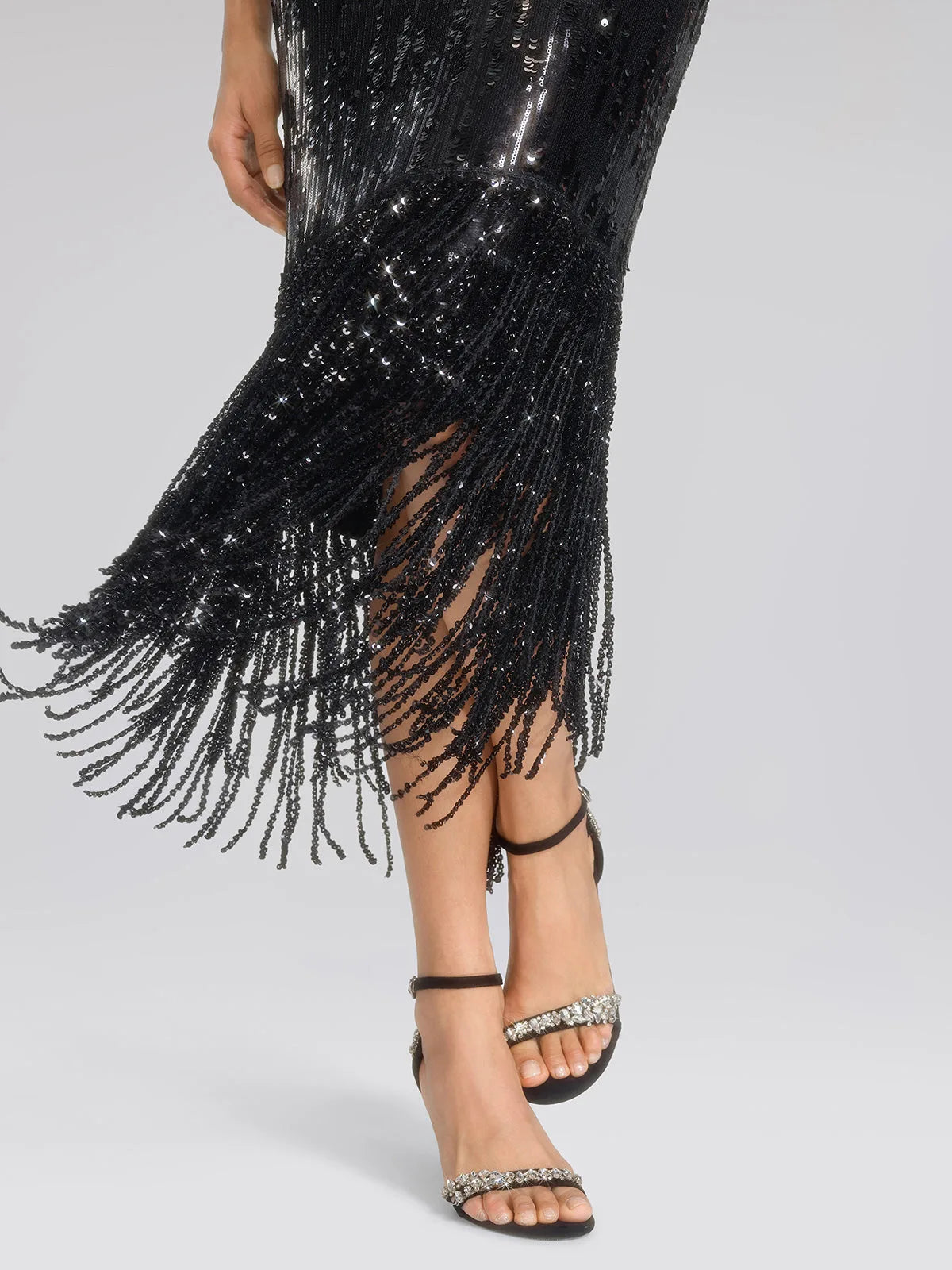 Women's black sequin fringe midi skirt with slit, close-up of the fringe hem in motion