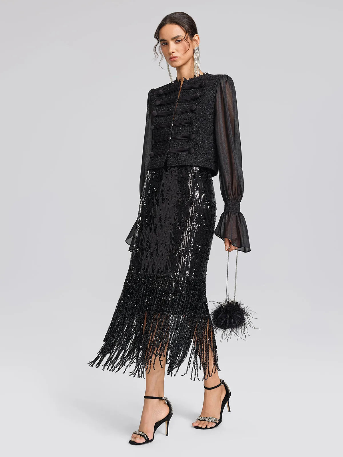 Women's black sequin fringe midi skirt with slit, styled with a black jacket and fringe skirt