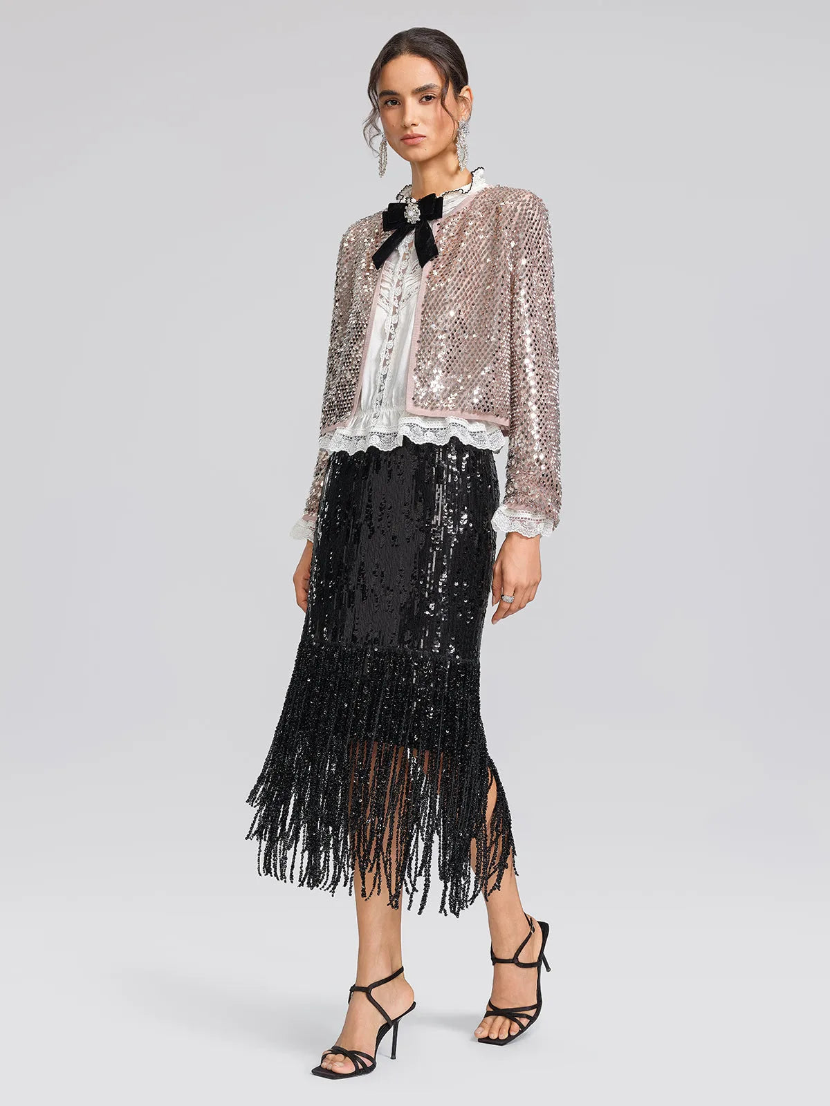 Women's black sequin fringe midi skirt with slit, styled with a cropped sparkly jacket