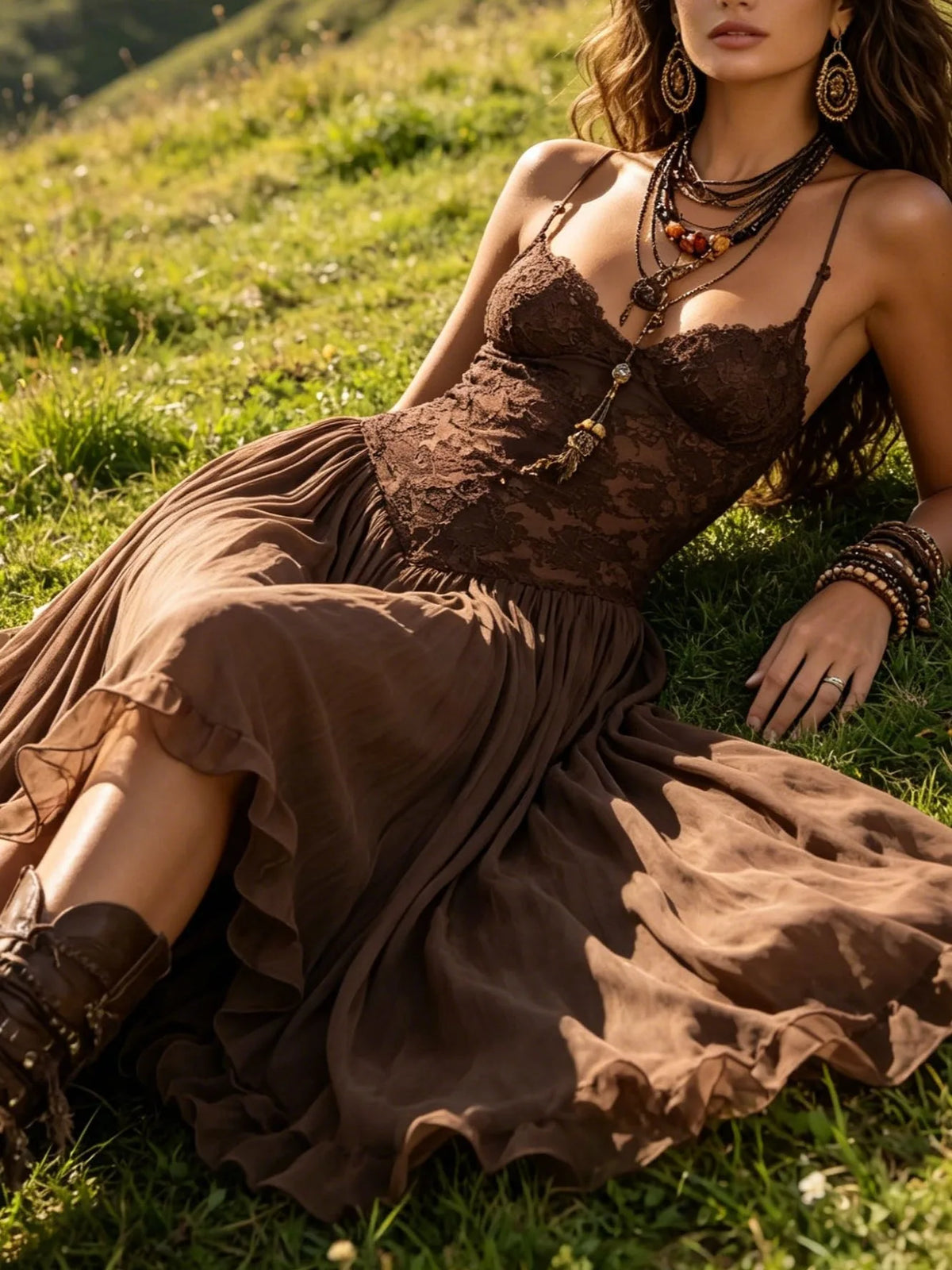 Women's brown lace-bodice maxi dress with flowing skirt, seated outdoors