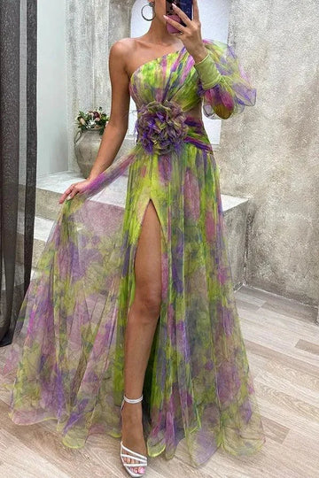 Women's floral print one-shoulder maxi dress with slit and flower detail, green, front view in a mirror