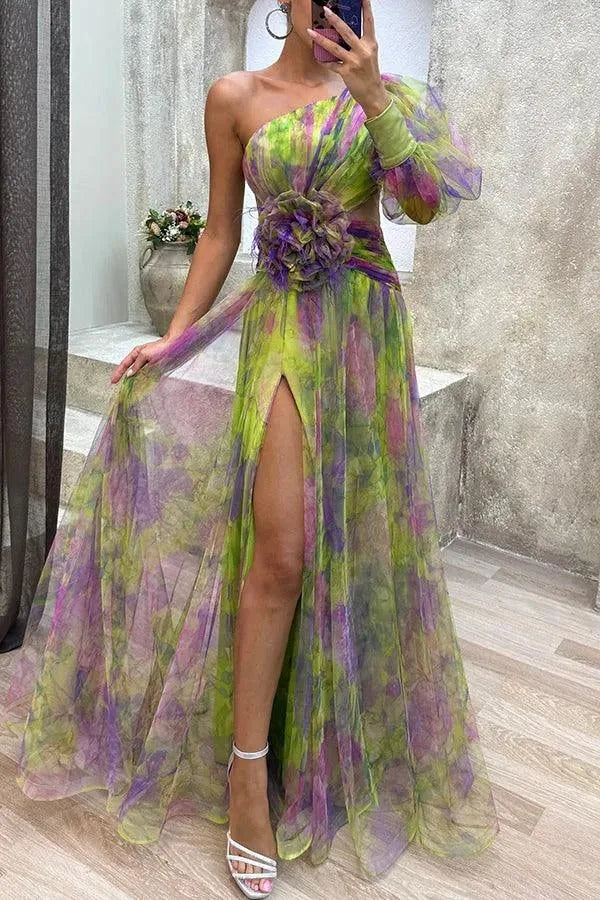 Women's floral print one-shoulder maxi dress with slit and flower detail, green, front view in a mirror