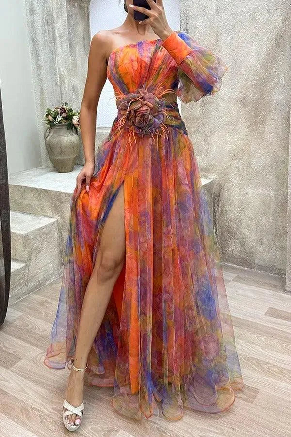 Women's floral print one-shoulder maxi dress with slit and flower detail, orange, front view in a mirror