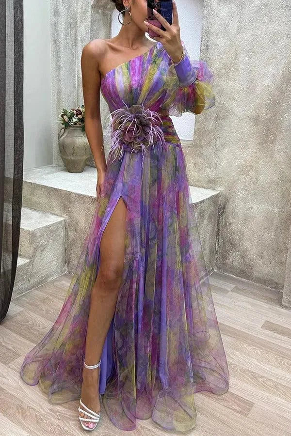 Women's floral print one-shoulder maxi dress with slit and flower detail, purple, front view in a mirror