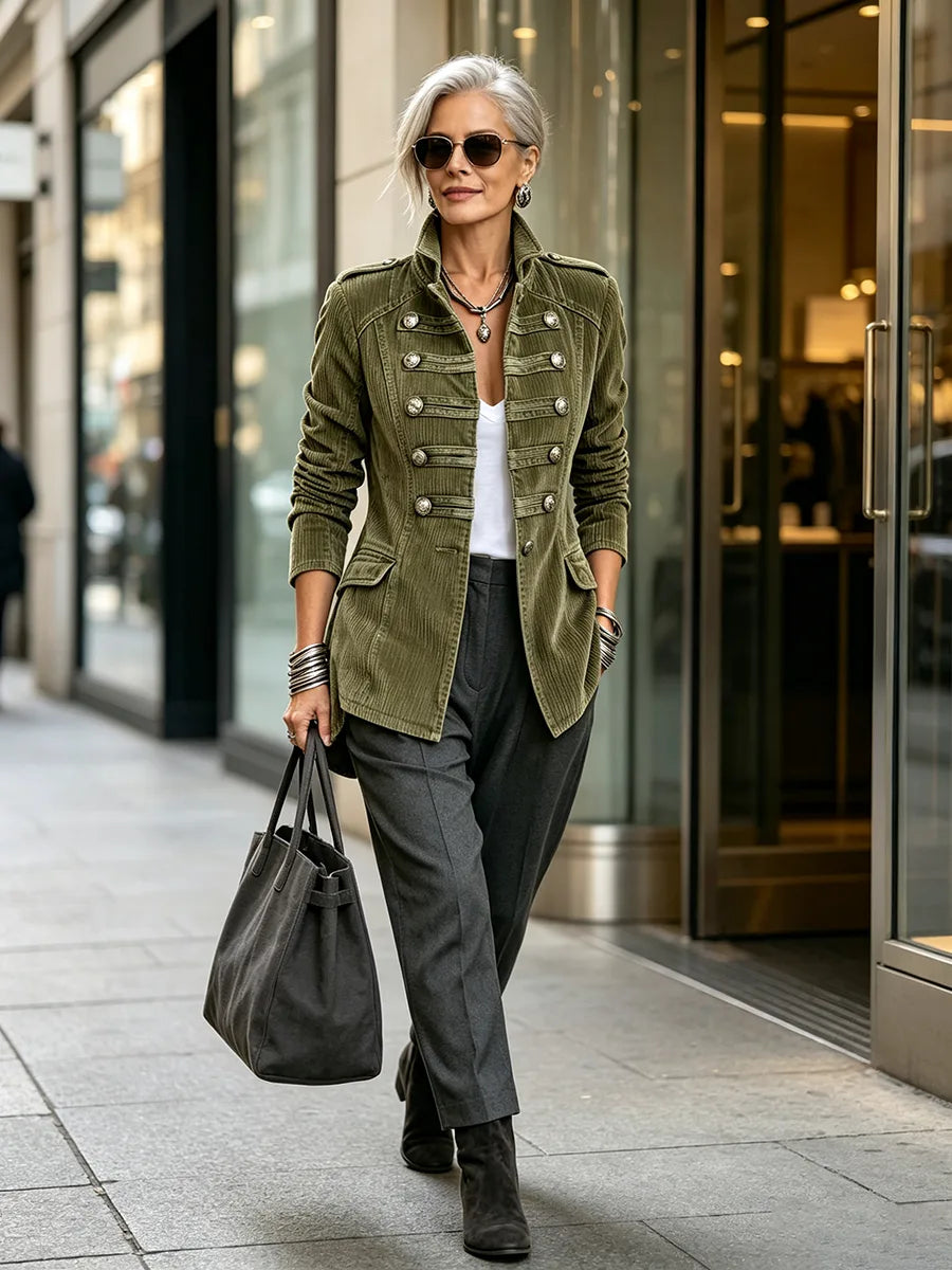 Women's olive military-style jacket with double row of metal buttons, styled with a tote bag outdoors