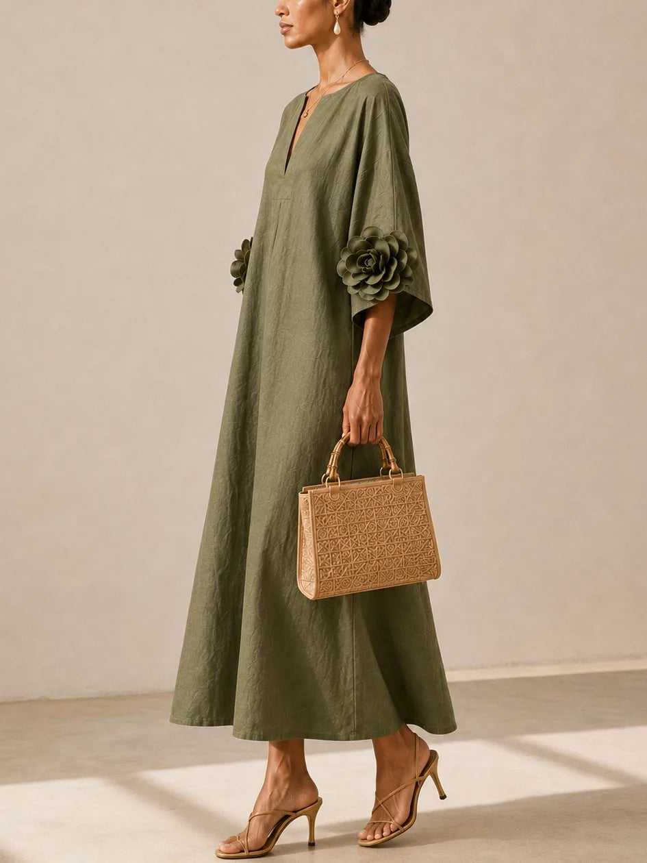 Women's olive green midi dress with floral appliqué sleeves, side view with handbag