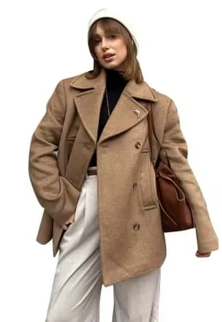 Women's oversized double-breasted camel coat with lapels, front view with brown handbag