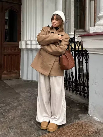 Women's oversized double-breasted camel coat with lapels, styled with wide-leg trousers