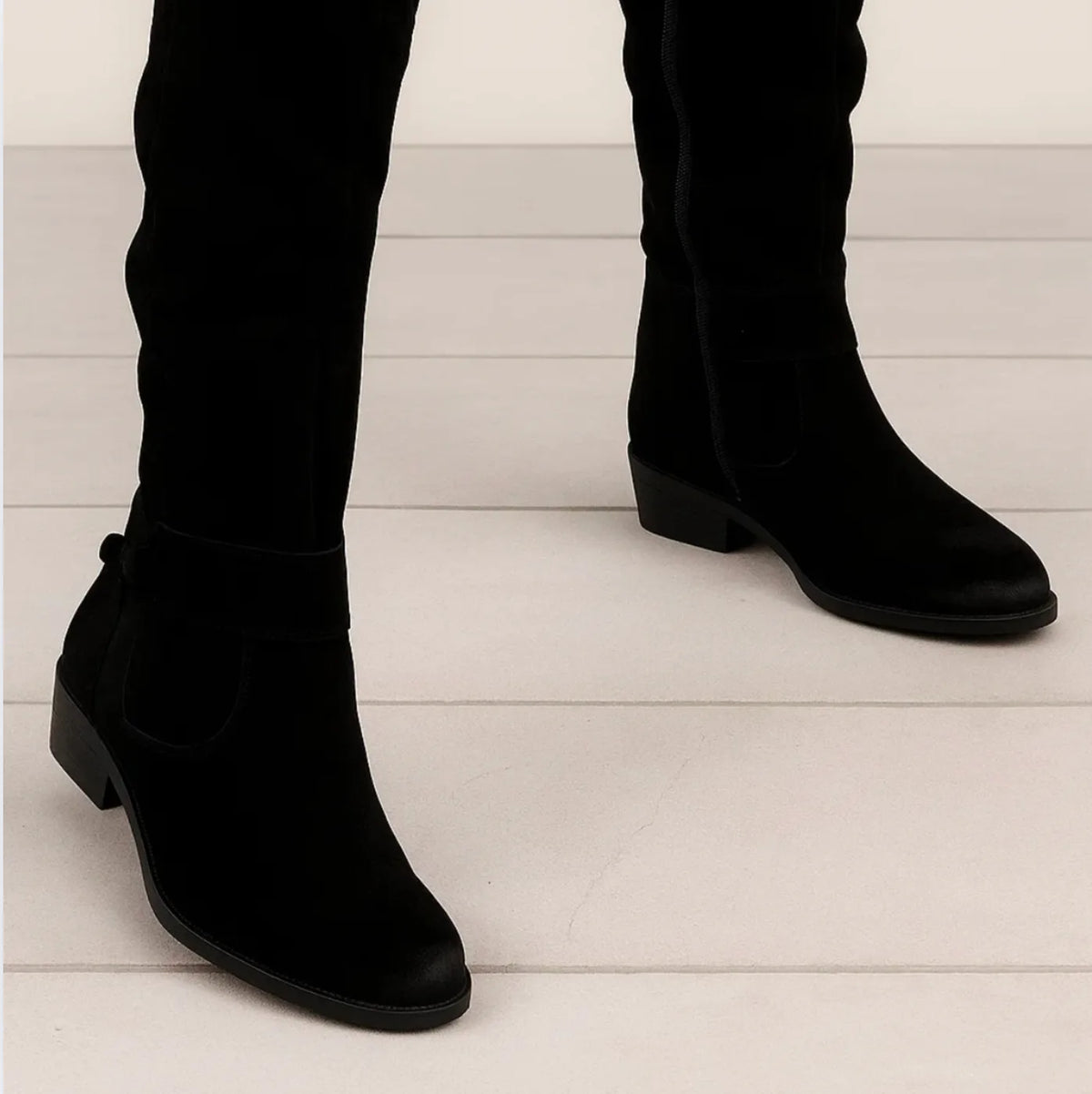 Women's slouchy knee-high boots with buckle strap, black, worn close-up
