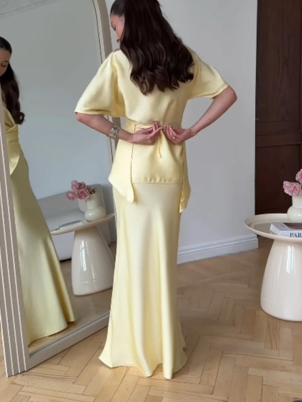Women's yellow off-shoulder wrap top and long skirt set, back view in the mirror