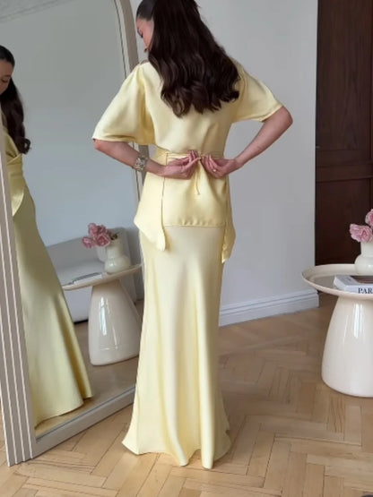 Women's yellow off-shoulder wrap top and long skirt set, back view in the mirror